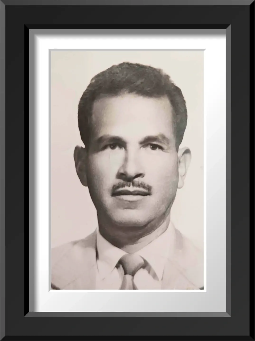 Retrato de Luis Flores Sánchez, fundador de Viajes Flosan, de traje y corbata, en un marco negro
